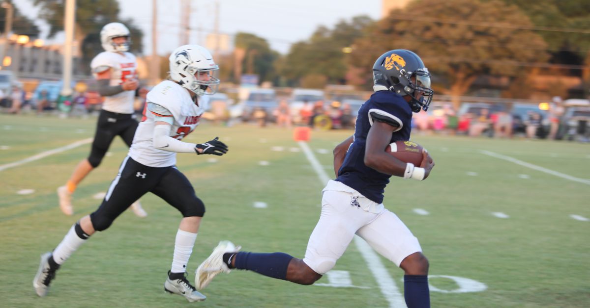 WCS Football player rushes the ball down the field.